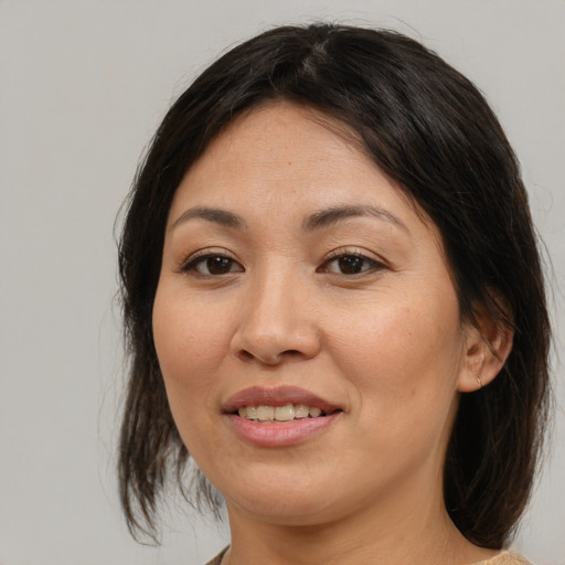 Joyful asian adult female with medium  brown hair and brown eyes