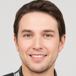 Joyful white young-adult male with short  brown hair and grey eyes