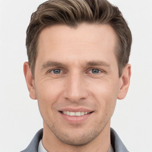 Joyful white young-adult male with short  brown hair and grey eyes