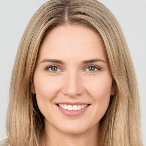 Joyful white young-adult female with long  brown hair and brown eyes