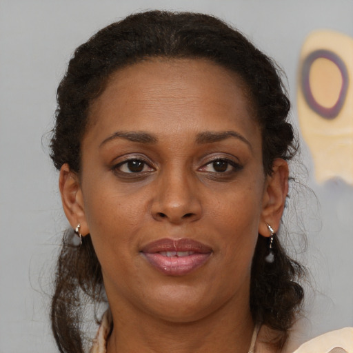 Joyful black adult female with medium  brown hair and brown eyes