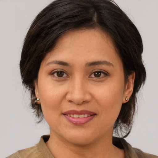 Joyful asian adult female with medium  brown hair and brown eyes