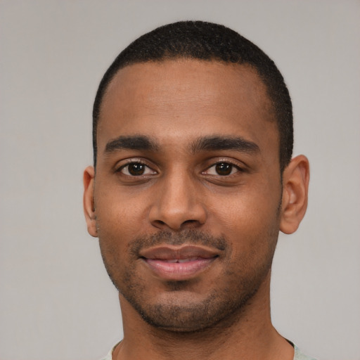 Joyful black young-adult male with short  black hair and brown eyes