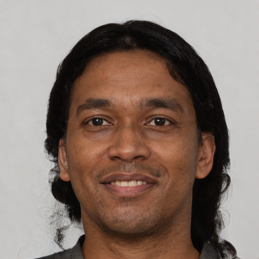 Joyful black adult male with short  black hair and brown eyes