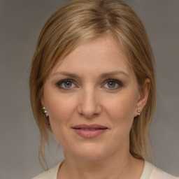 Joyful white young-adult female with medium  brown hair and grey eyes