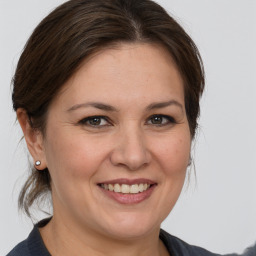 Joyful white adult female with medium  brown hair and grey eyes