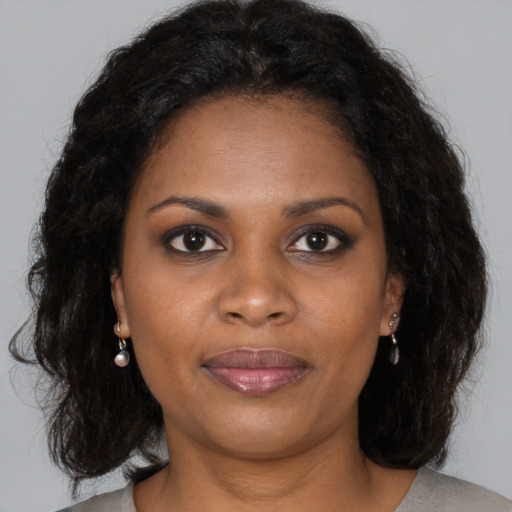 Joyful black adult female with medium  brown hair and brown eyes