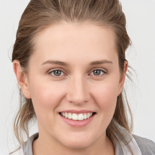 Joyful white young-adult female with medium  brown hair and grey eyes