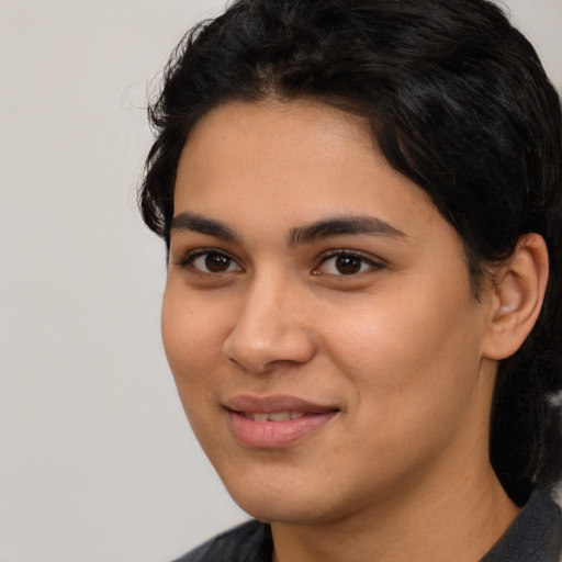 Joyful latino young-adult female with long  black hair and brown eyes