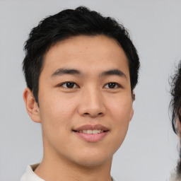 Joyful asian young-adult male with short  black hair and brown eyes