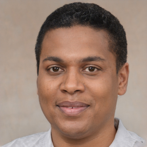 Joyful black young-adult male with short  black hair and brown eyes