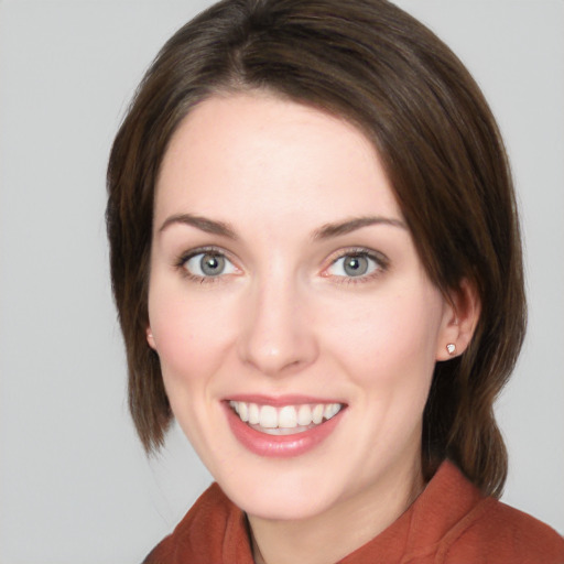 Joyful white young-adult female with medium  brown hair and green eyes