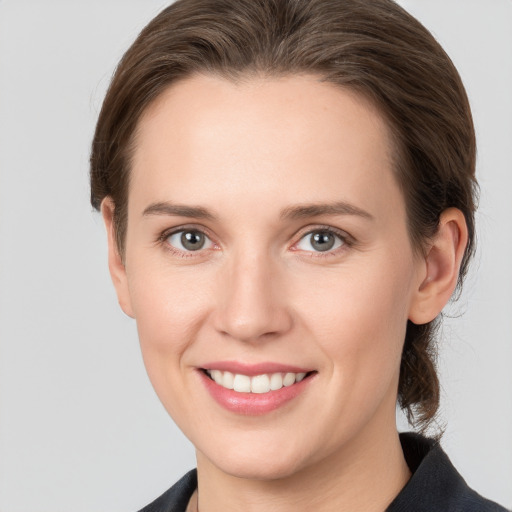 Joyful white young-adult female with medium  brown hair and grey eyes