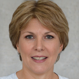 Joyful white adult female with medium  brown hair and blue eyes