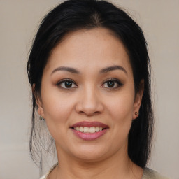 Joyful latino young-adult female with medium  brown hair and brown eyes