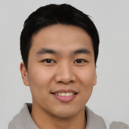 Joyful asian young-adult male with short  black hair and brown eyes