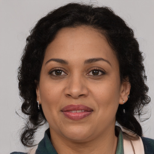 Joyful latino adult female with medium  brown hair and brown eyes