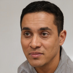 Joyful latino adult male with short  black hair and brown eyes