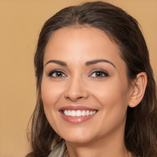 Joyful white young-adult female with long  brown hair and brown eyes