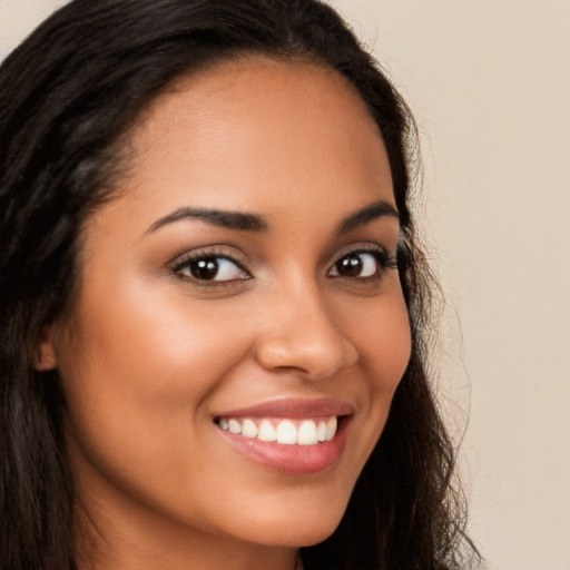 Joyful latino young-adult female with long  brown hair and brown eyes