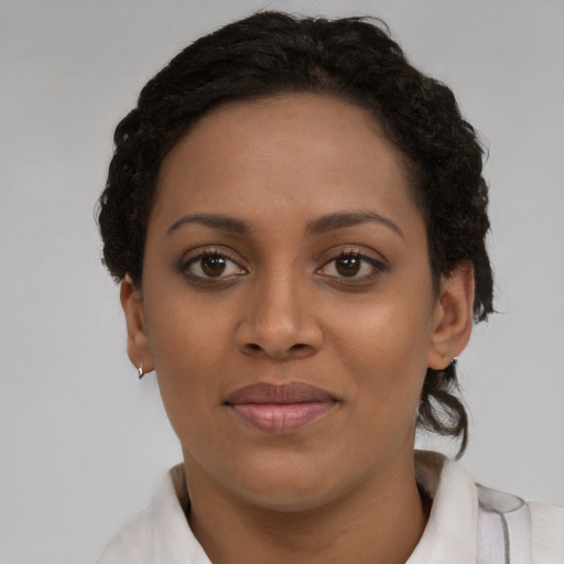 Joyful black young-adult female with short  brown hair and brown eyes