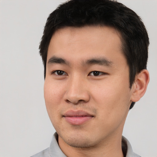 Joyful asian young-adult male with short  black hair and brown eyes