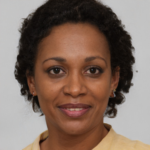 Joyful black adult female with short  brown hair and brown eyes