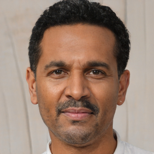 Joyful latino adult male with short  black hair and brown eyes