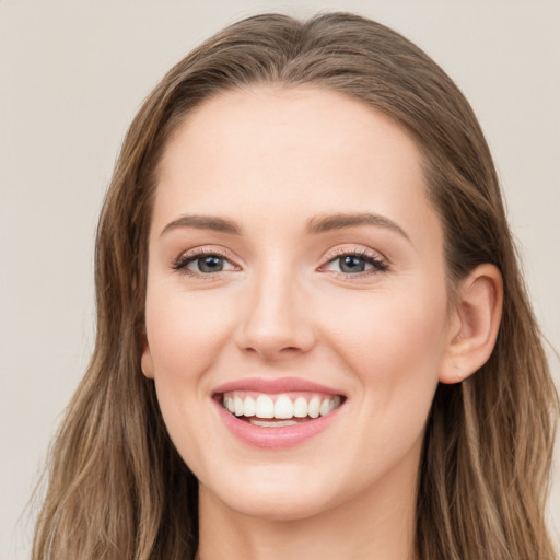 Joyful white young-adult female with long  brown hair and blue eyes