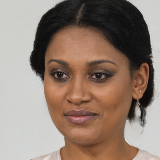 Joyful black adult female with medium  brown hair and brown eyes