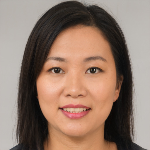 Joyful asian young-adult female with long  brown hair and brown eyes