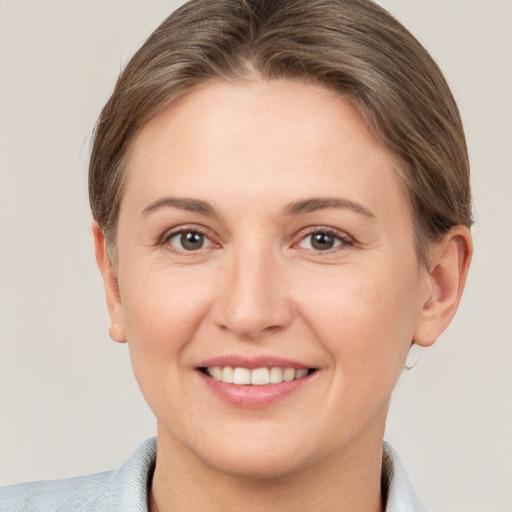 Joyful white young-adult female with short  brown hair and grey eyes