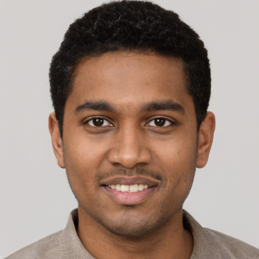 Joyful black young-adult male with short  black hair and brown eyes