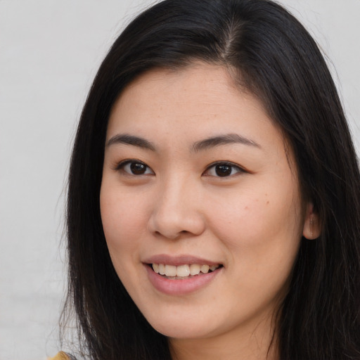 Joyful asian young-adult female with long  brown hair and brown eyes