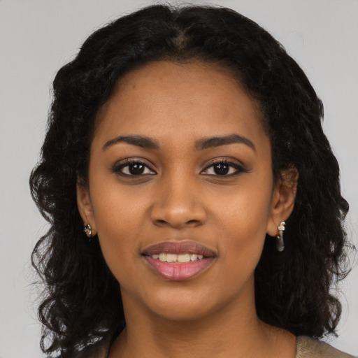 Joyful black young-adult female with long  black hair and brown eyes
