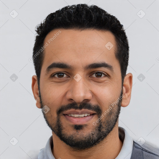 Joyful latino young-adult male with short  black hair and brown eyes