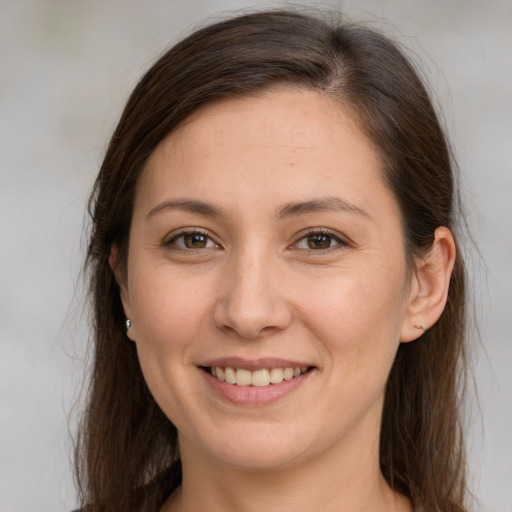 Joyful white young-adult female with long  brown hair and grey eyes