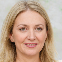 Joyful white adult female with medium  brown hair and green eyes