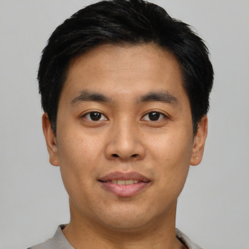 Joyful asian young-adult male with short  black hair and brown eyes