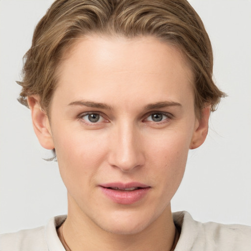 Joyful white young-adult female with short  brown hair and grey eyes