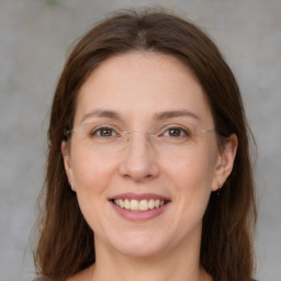 Joyful white adult female with medium  brown hair and grey eyes