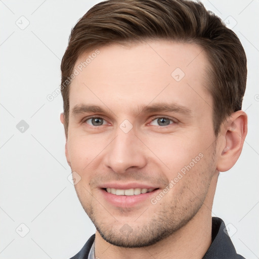 Joyful white young-adult male with short  brown hair and grey eyes