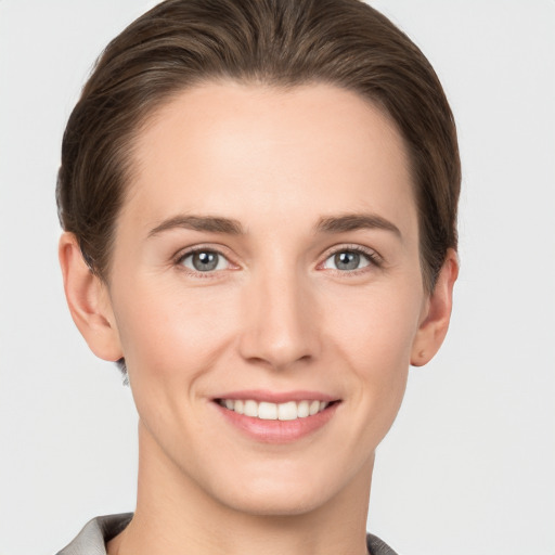 Joyful white young-adult female with short  brown hair and grey eyes