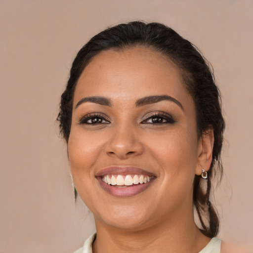 Joyful latino young-adult female with medium  brown hair and brown eyes