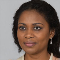 Joyful black young-adult female with long  brown hair and brown eyes