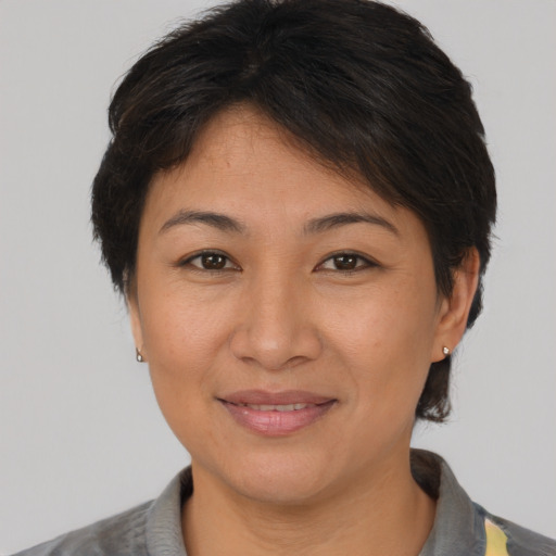 Joyful asian young-adult female with short  brown hair and brown eyes