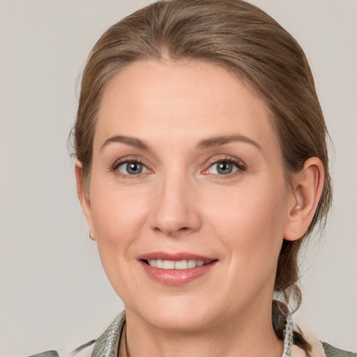 Joyful white adult female with medium  brown hair and grey eyes