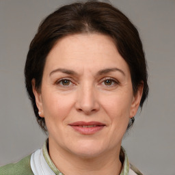 Joyful white adult female with medium  brown hair and grey eyes