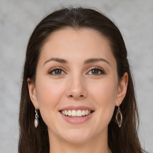 Joyful white young-adult female with long  brown hair and green eyes