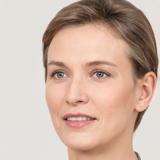 Joyful white young-adult female with short  brown hair and grey eyes